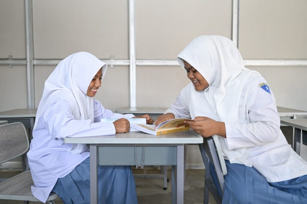 dua-siswa-sma-berjilbab-duduk-baca-buku