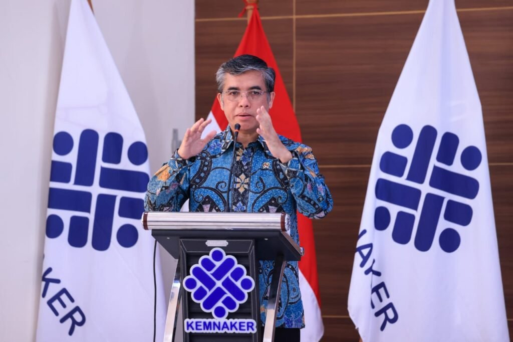 yassierli-kemnaker-podium-latar-bendera