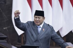 kepal tangan prabowo di podium merah putih latar